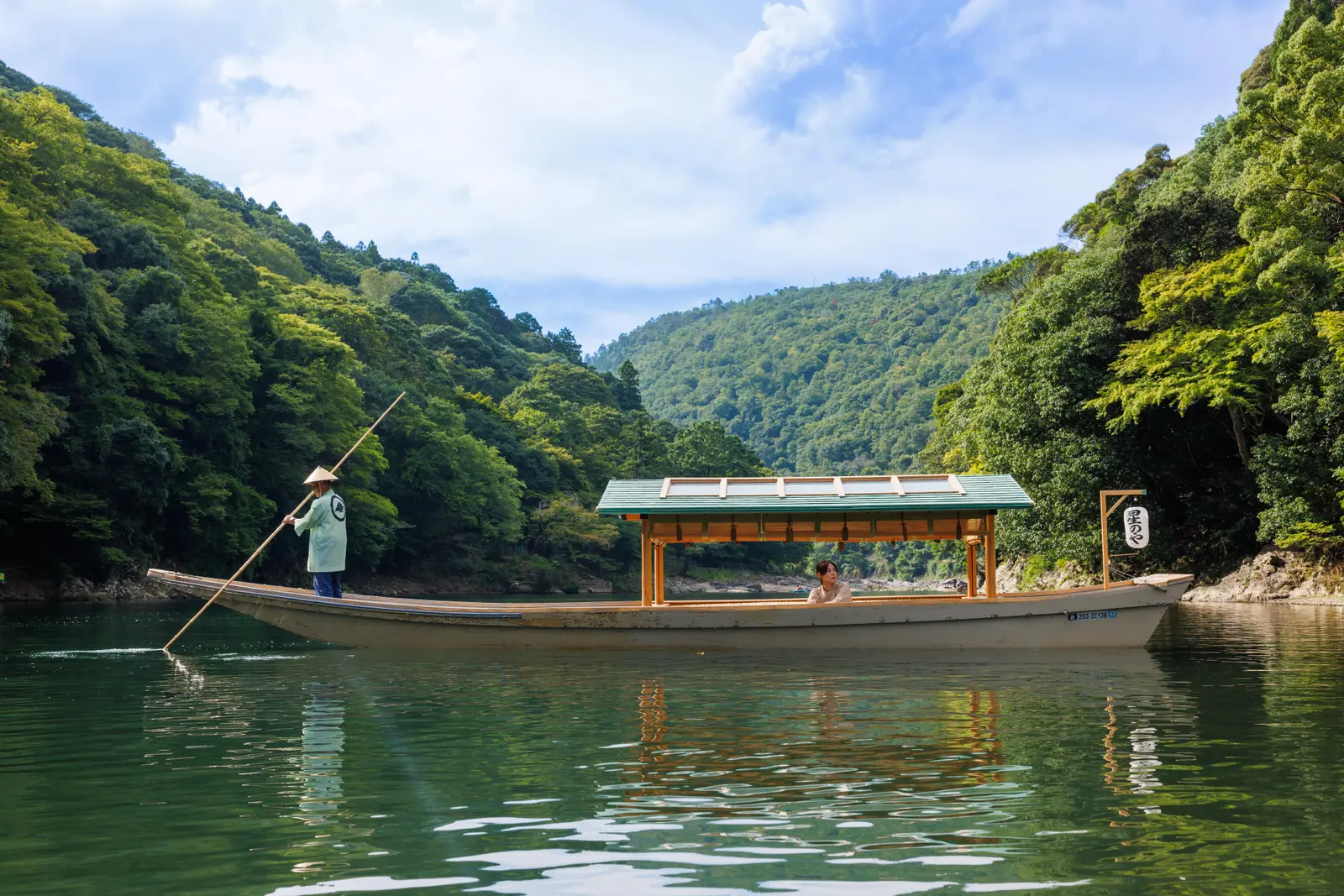 HOSHINOYA Kyoto arrival boat on the Oi River below forested Arashiyama hills